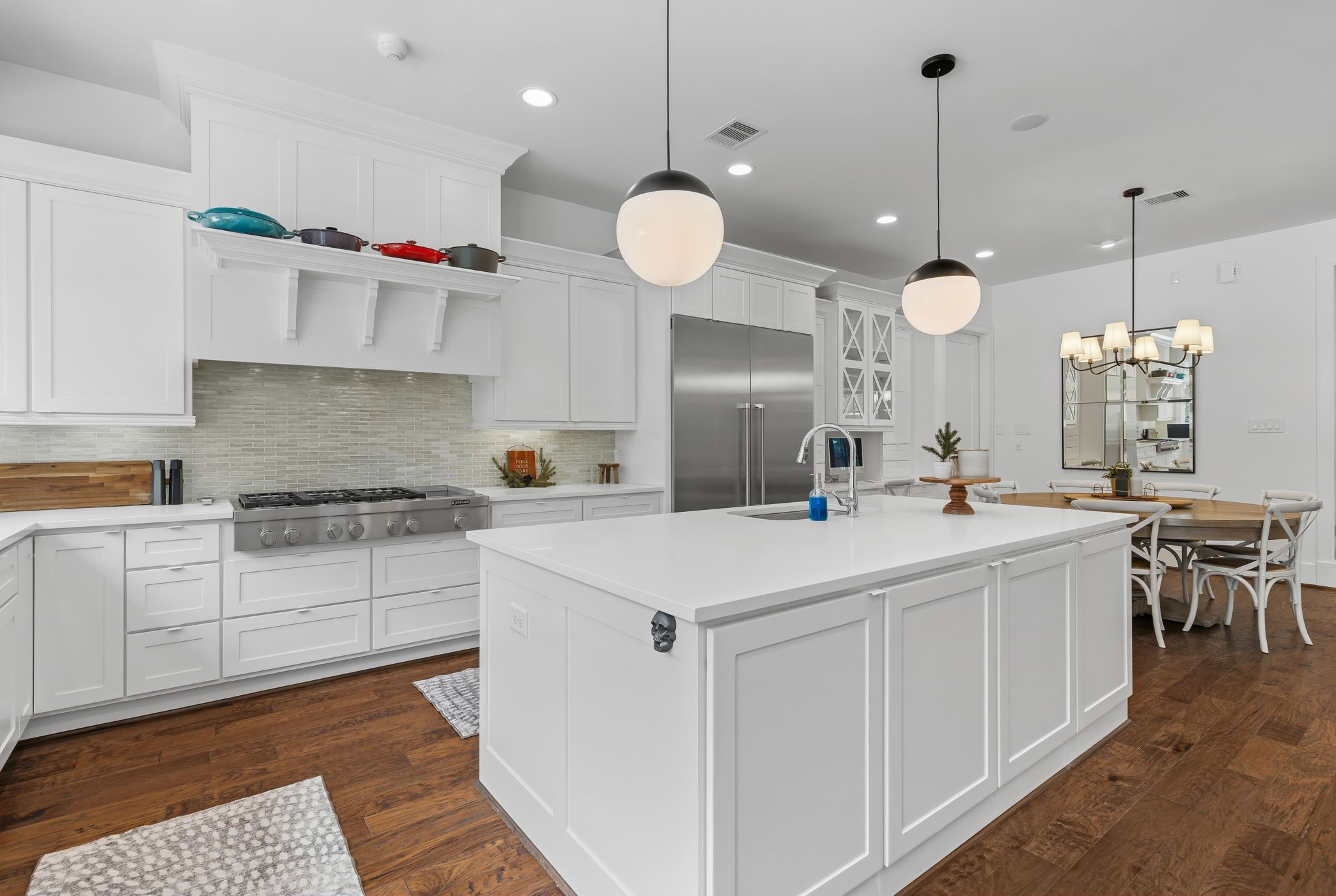 10 Riata Drive Magnolia, TX 77354 - Photo 21 of 48 White quartz kitchen countertops and white Shaker-style cabinets with soft-close doors + drawers contrast beautifully with the warm tones in the wood flooring and backsplash tile.