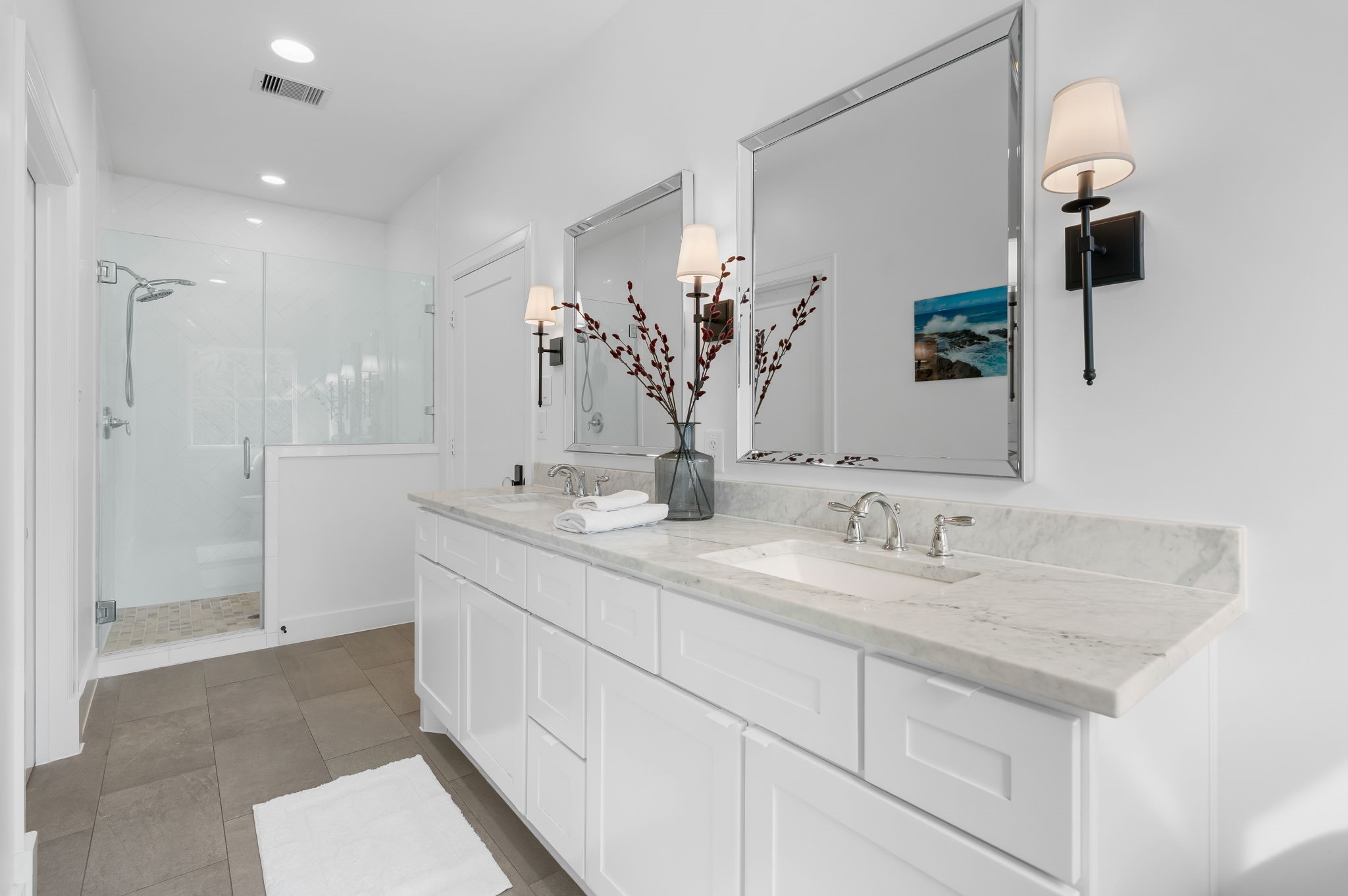 10 Riata Drive Magnolia, TX 77354 - Photo 35 of 48 Primary bathroom with Carrera marble counters, chrome fixtures, double sinks and a spacious shower. There is a large space in the adjacent walk in attic that could be used to expand the size of this primary bathroom. The home is energy efficient with white roof, Tech shield, high SEER HVAC's and the recent addition of additional insulation.