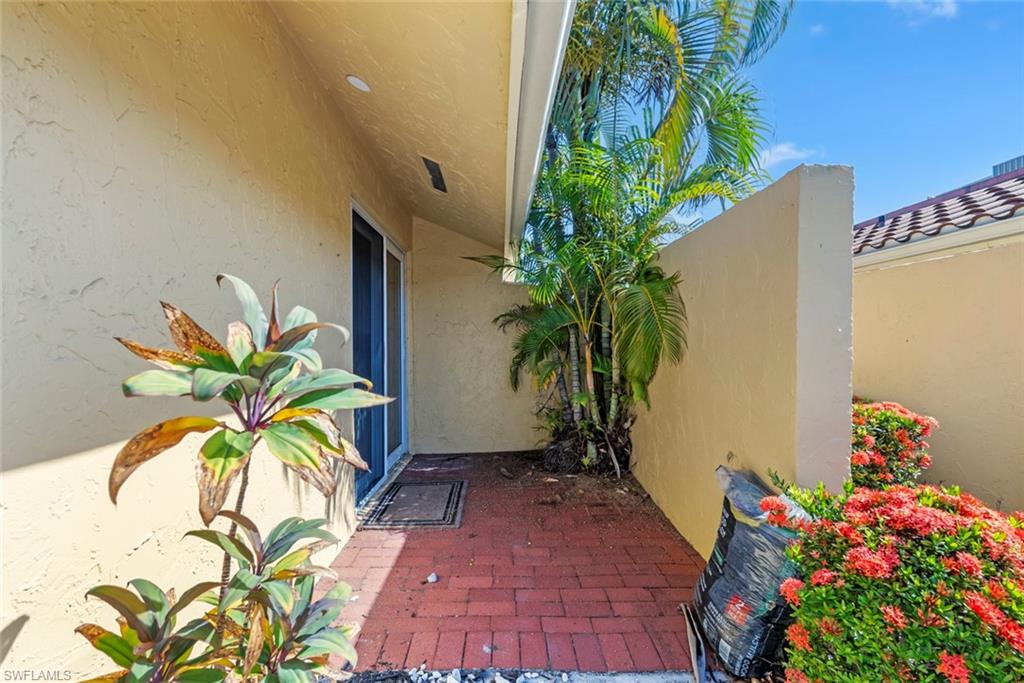 136 Harrison Road, Unit 1 Naples, FL 34112 - Photo 18 of 29 Brick paver patio with perimeter privacy wall