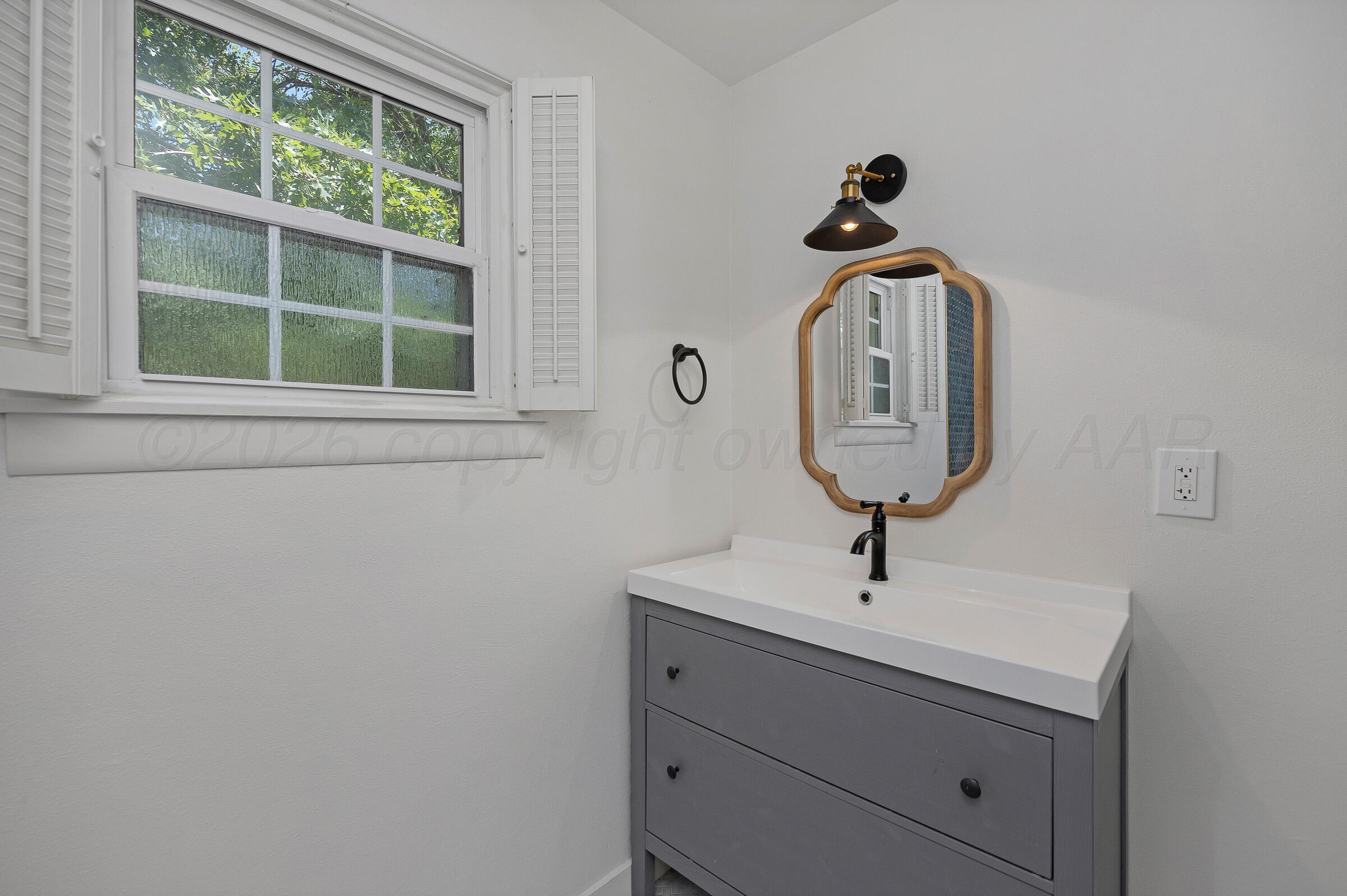 2102 South Hayden Street Amarillo, TX 79109 - Photo 35 of 44 a bathroom with a sink and a mirror