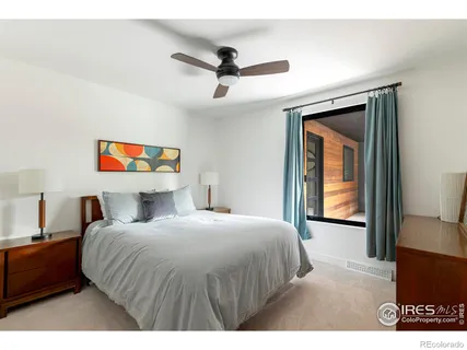 a bedroom with a bed and a painting on the wall