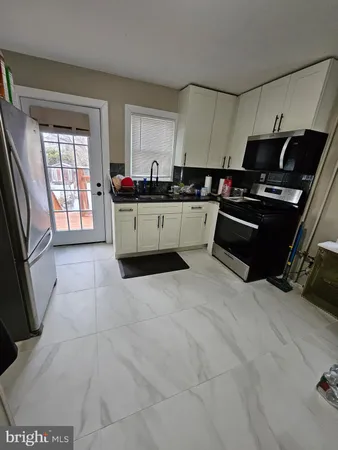 a kitchen with a sink a stove and cabinets