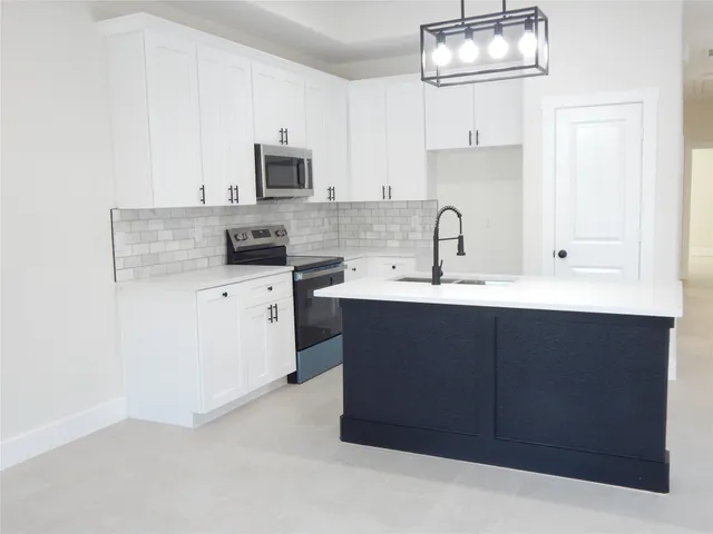 a kitchen with stainless steel appliances granite countertop a sink stove and microwave
