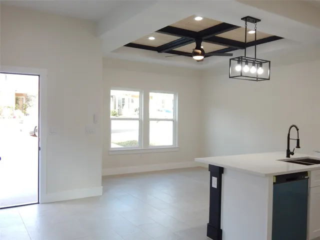 a view of a room with a ceiling fan and wooden floor