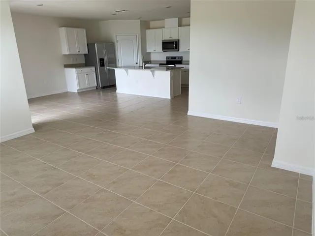 a view of kitchen with granite countertop a stove top oven and white cabinets