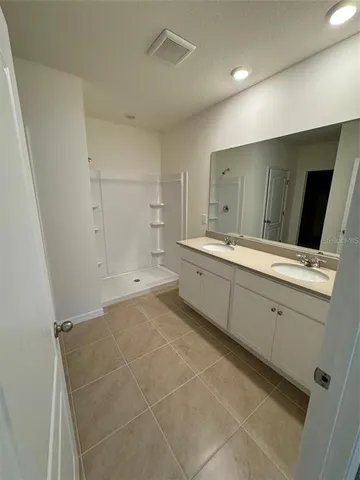 a bathroom with a sink a toilet and a large mirror