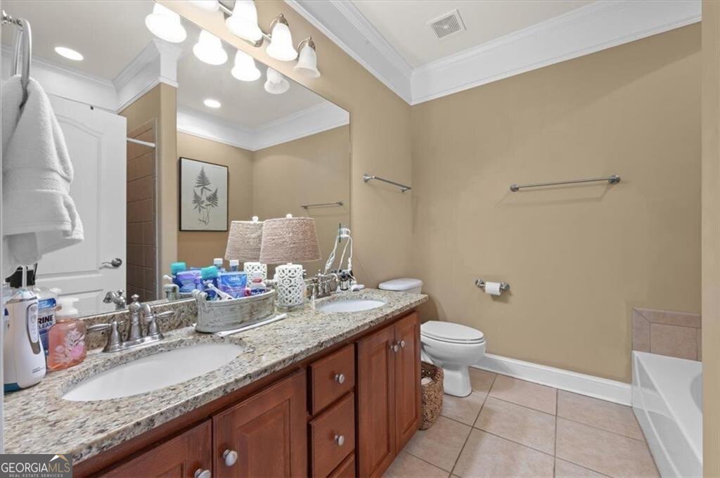 7272 Shellman Bluff Road Northeast, Unit 21 Townsend, GA 31331 - Photo 16 of 33 a bathroom with a granite countertop sink a large mirror and toilet