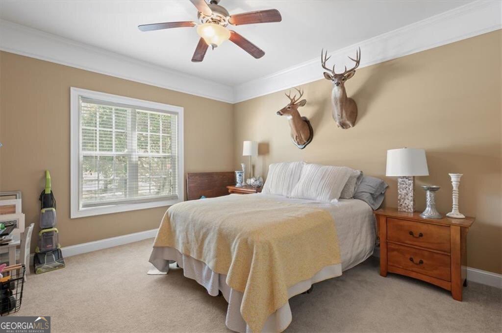 7272 Shellman Bluff Road Northeast, Unit 21 Townsend, GA 31331 - Photo 23 of 33 a bedroom with a bed a chandelier and a window