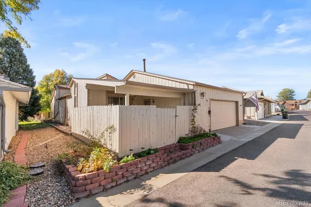 a view of a deck with wooden floor and fence with a large garden