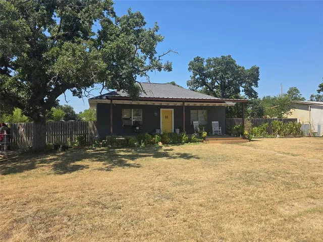 a view of a house with a yard and tree