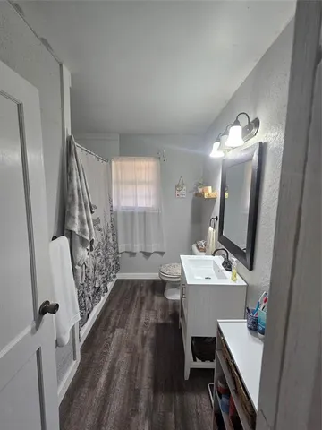 a bathroom with a sink a toilet a mirror and shower