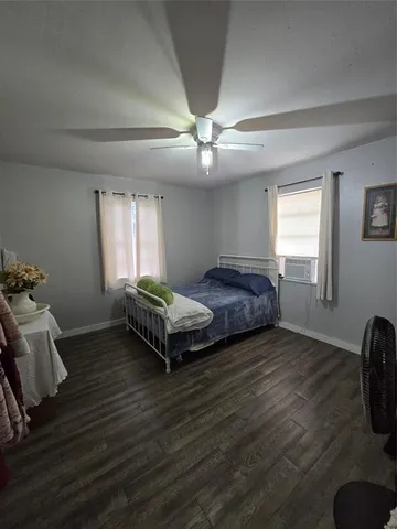 a bedroom with a bed wooden floor and window