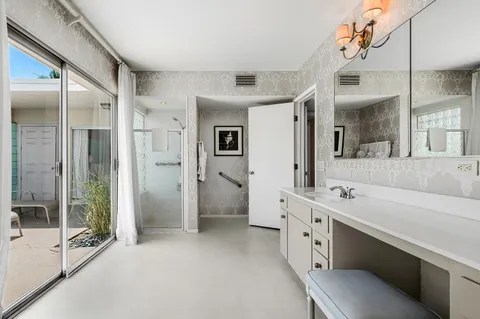 a bathroom with a double vanity sink mirror and shower