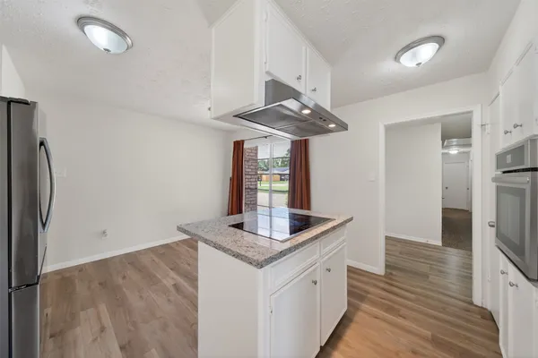 a kitchen with stainless steel appliances granite countertop a sink refrigerator and cabinets