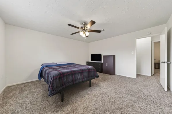 a bedroom with a bed and a ceiling fan