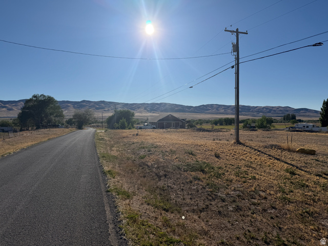 126 Burraston Road, Unit 2 Mona, UT 84645 - Photo 2 of 7 Paved roadway traversing a rural landscape with distant rolling hills