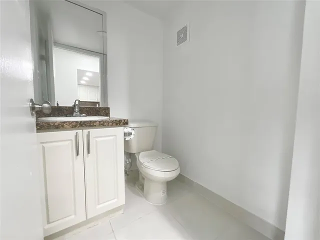 a white toilet sitting next to a bathroom sink