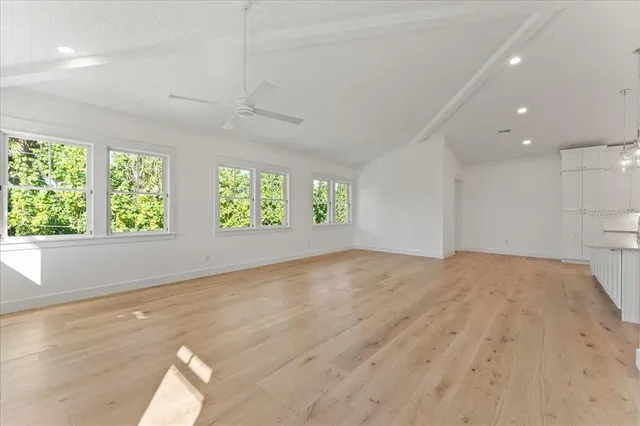 a large kitchen with stainless steel appliances a large counter top a refrigerator and a sink