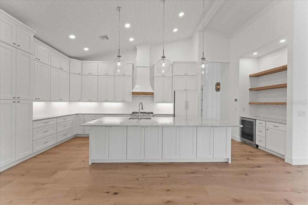 847 Belcher Road Boca Grande, FL 33921 - Photo 16 of 74 a large white kitchen with kitchen island white cabinetry and stainless steel appliances