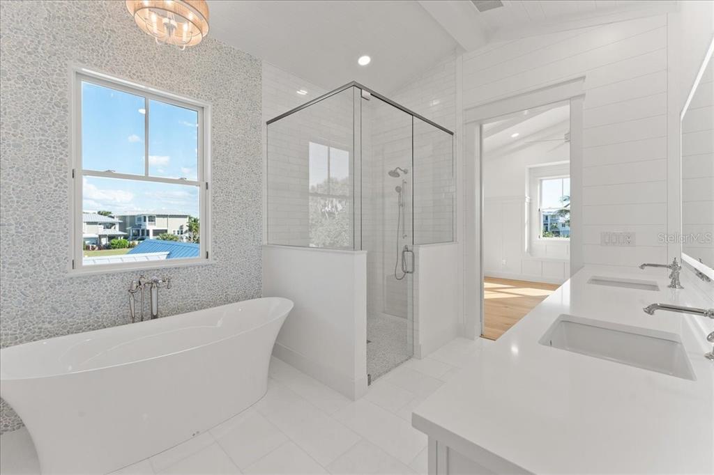 847 Belcher Road Boca Grande, FL 33921 - Photo 40 of 99 a bathroom with a tub a sink and a large mirror