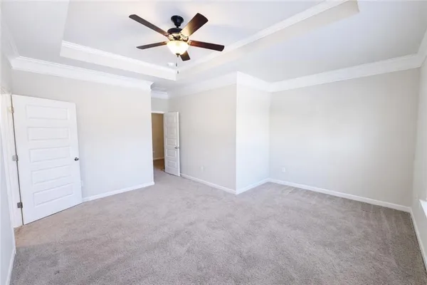 an empty room with closet and a ceiling fan