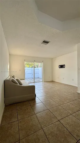 a living room with hard wood flooring and a glass door