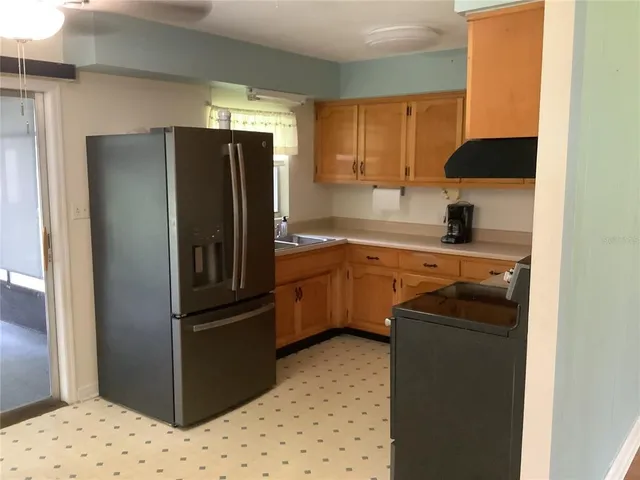 a kitchen with a refrigerator sink and cabinets