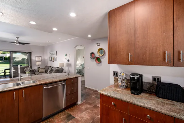 a kitchen with granite countertop a sink and cabinets