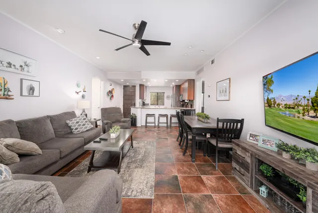 a living room with furniture and a flat screen tv with wooden floor