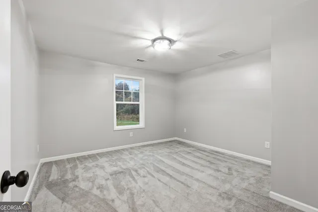 a view of a room with a ceiling fan and window