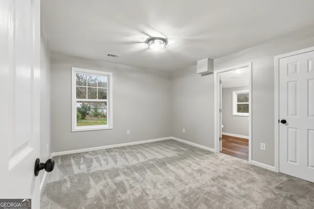an empty room with windows and closet