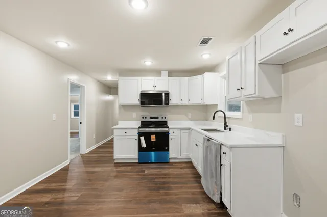 a kitchen with stainless steel appliances granite countertop a sink and stove top oven