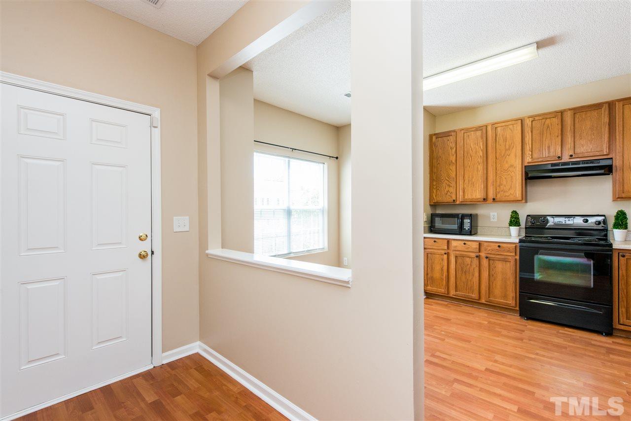 106 Eldon Lane Apex, NC 27502 - Photo 3 of 22 a kitchen with a refrigerator stove and wooden cabinets