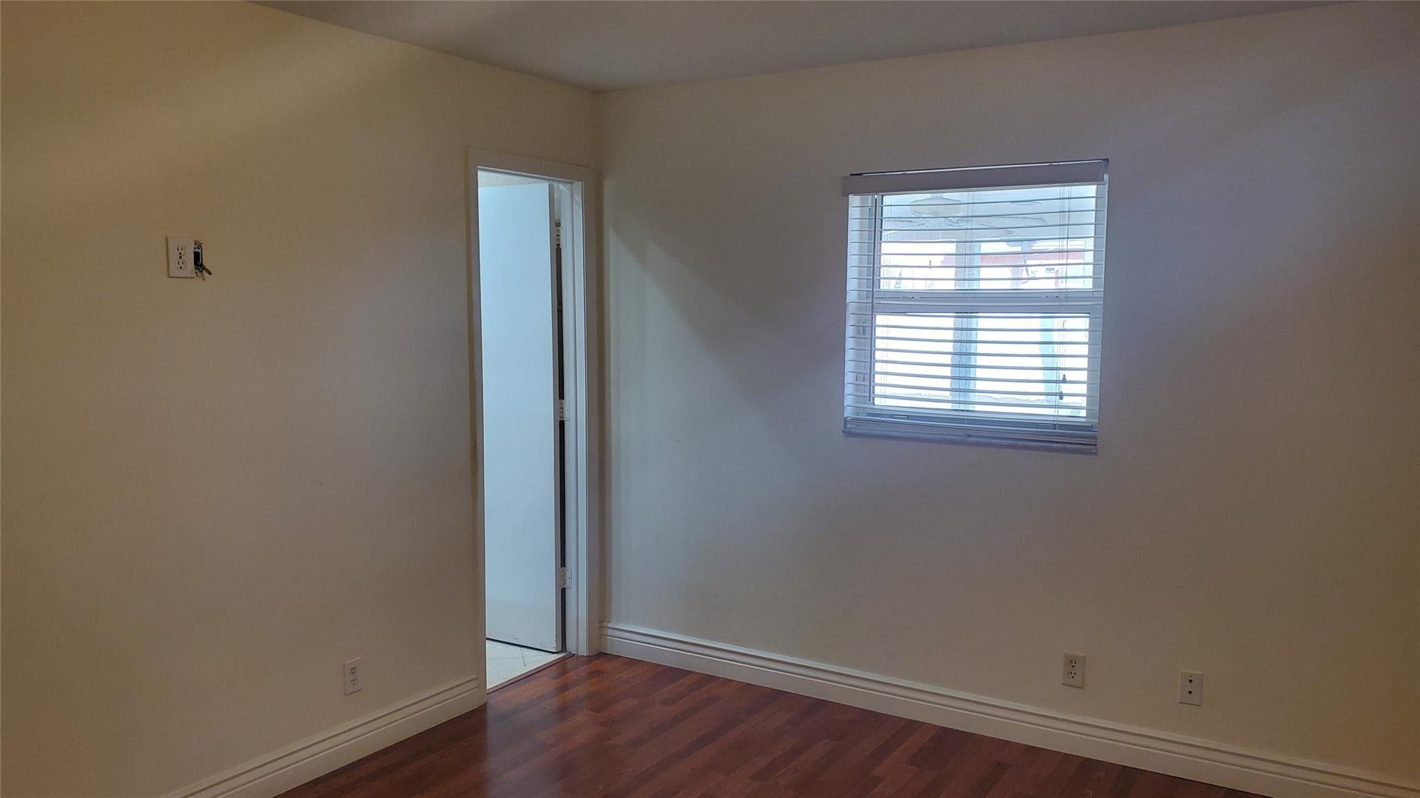 10734 Shady Pond Lane Boca Raton, FL 33428 - Photo 14 of 23 an empty room with wooden floor and a window