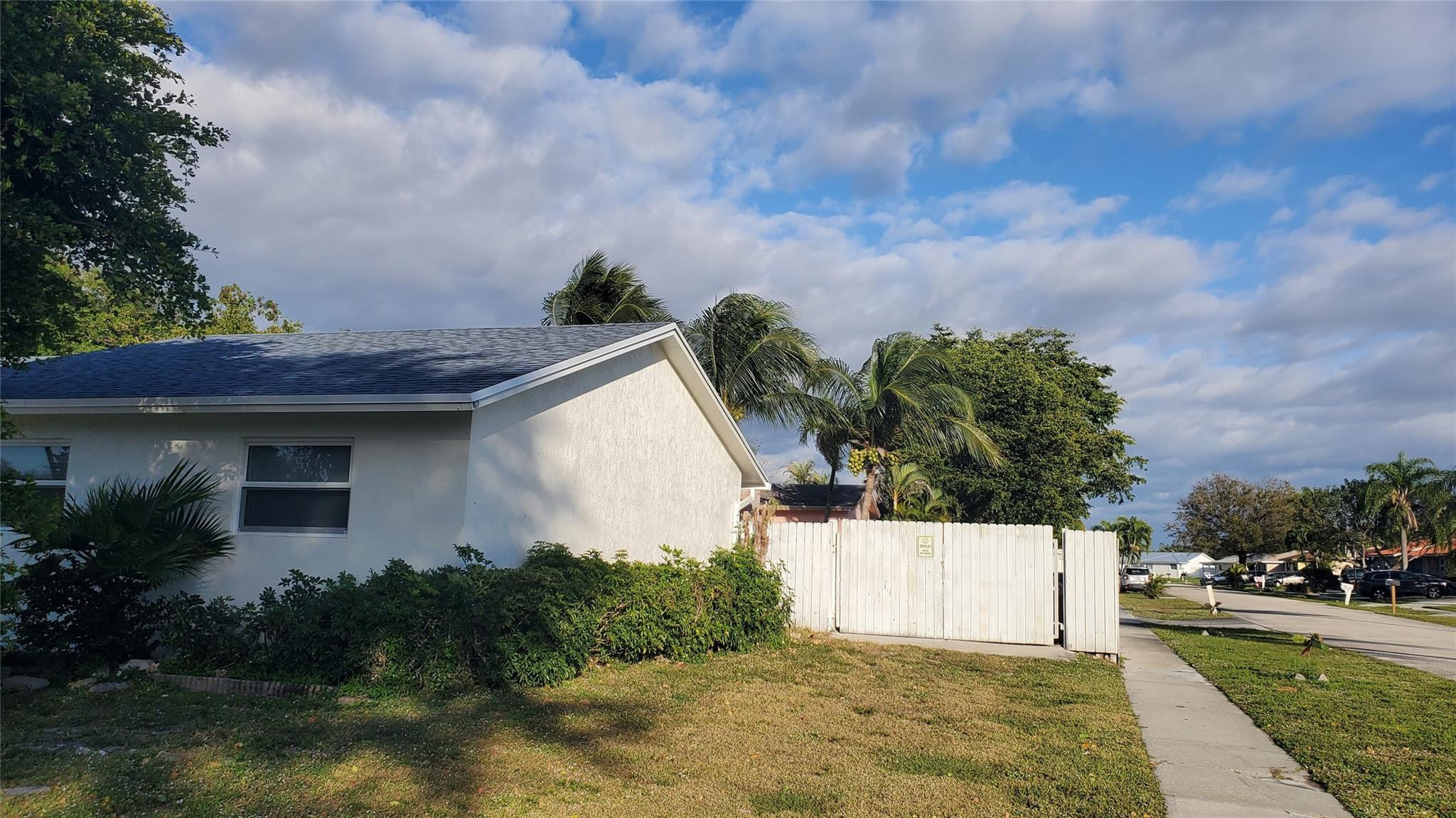 10734 Shady Pond Lane Boca Raton, FL 33428 - Photo 2 of 23 a view of a white house with a yard and plants