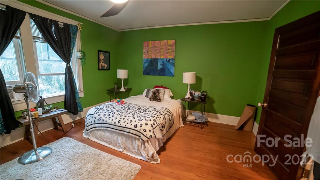 100 Morehead Street Morganton, NC 28655 - Photo 29 of 37 a bedroom with a bed wooden floor and a flat screen tv