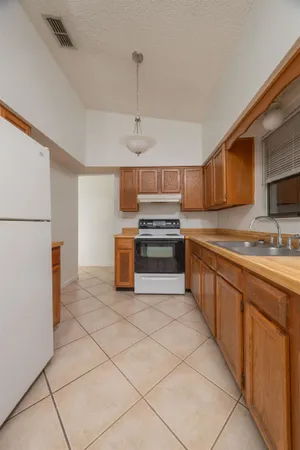 a kitchen with stainless steel appliances granite countertop a stove top oven a sink and a refrigerator