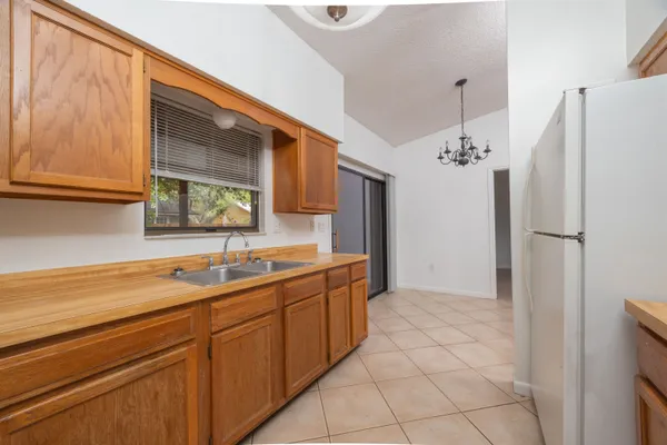 a kitchen with a sink a refrigerator and a stove top oven