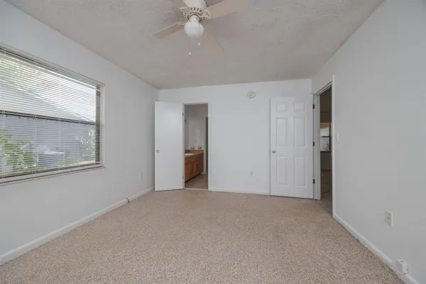 an empty room with fan and windows
