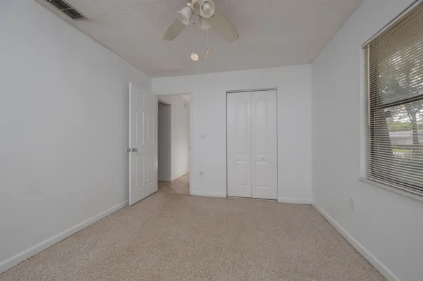 an empty room with chandelier fan