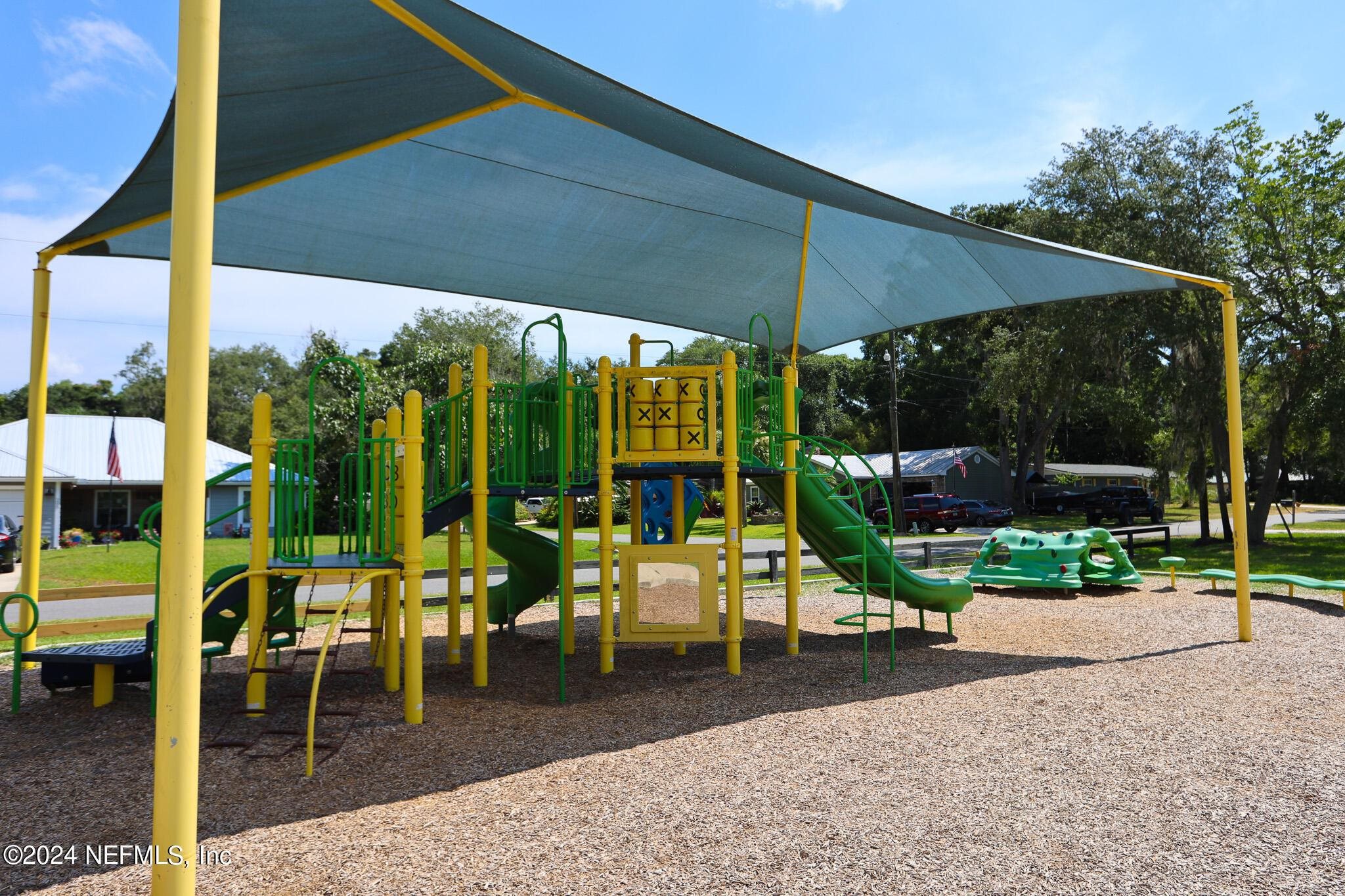 114 Lobelia Road St. Augustine, FL 32086 - Photo 34 of 38 a view of a patio with table and chairs potted plants and palm trees