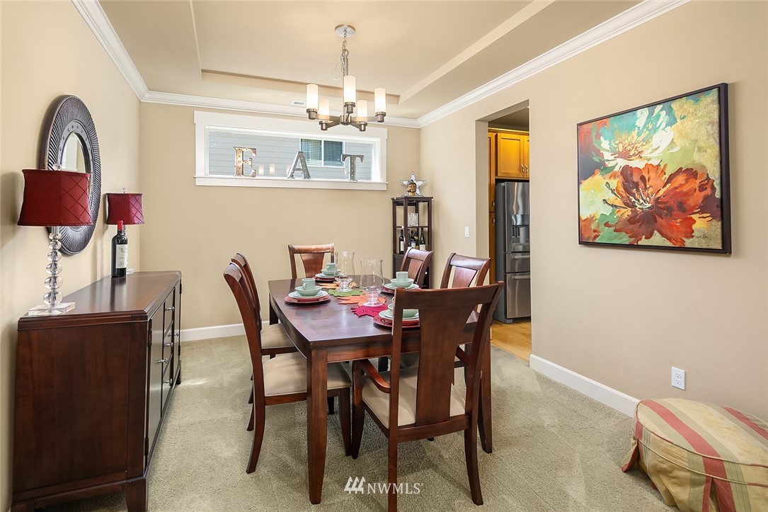 6308 Southeast 2nd Street Renton, WA 98059 - Photo 12 of 29 a view of a dining room with furniture a chandelier and wooden floor