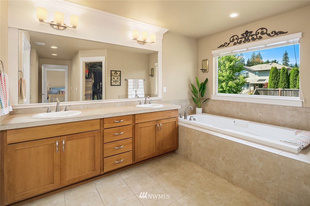 6308 Southeast 2nd Street Renton, WA 98059 - Photo 16 of 29 a spacious bathroom with a granite countertop sink mirror and a bathtub