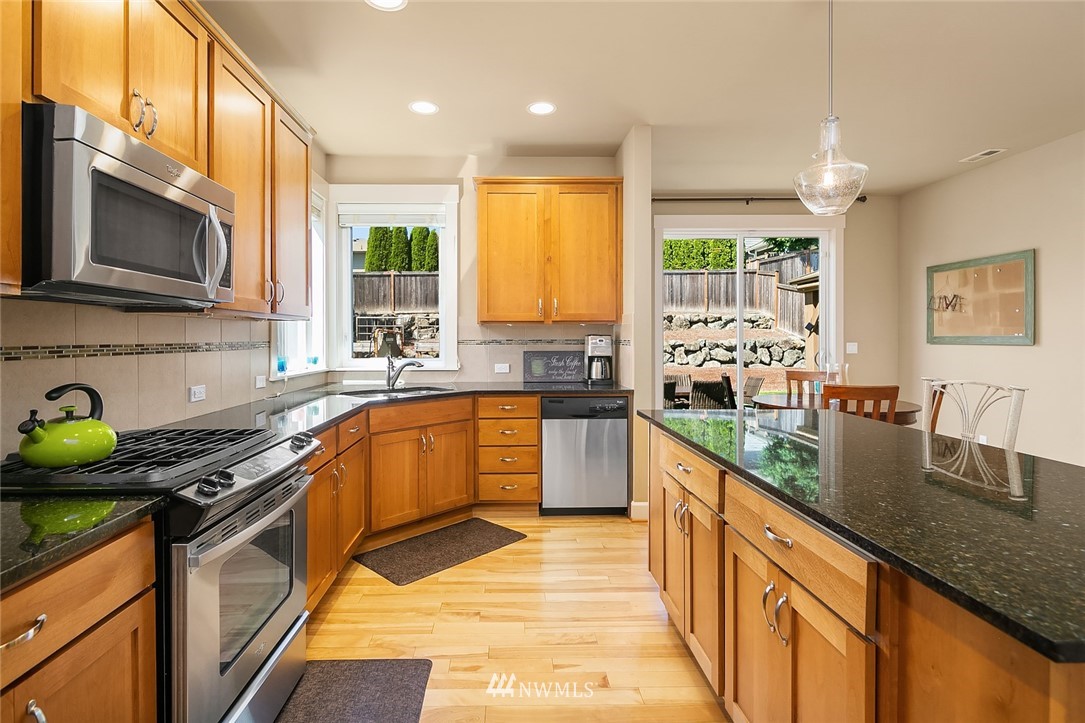 6308 Southeast 2nd Street Renton, WA 98059 - Photo 9 of 29 a kitchen with stainless steel appliances granite countertop a sink a stove top oven a counter space and cabinets