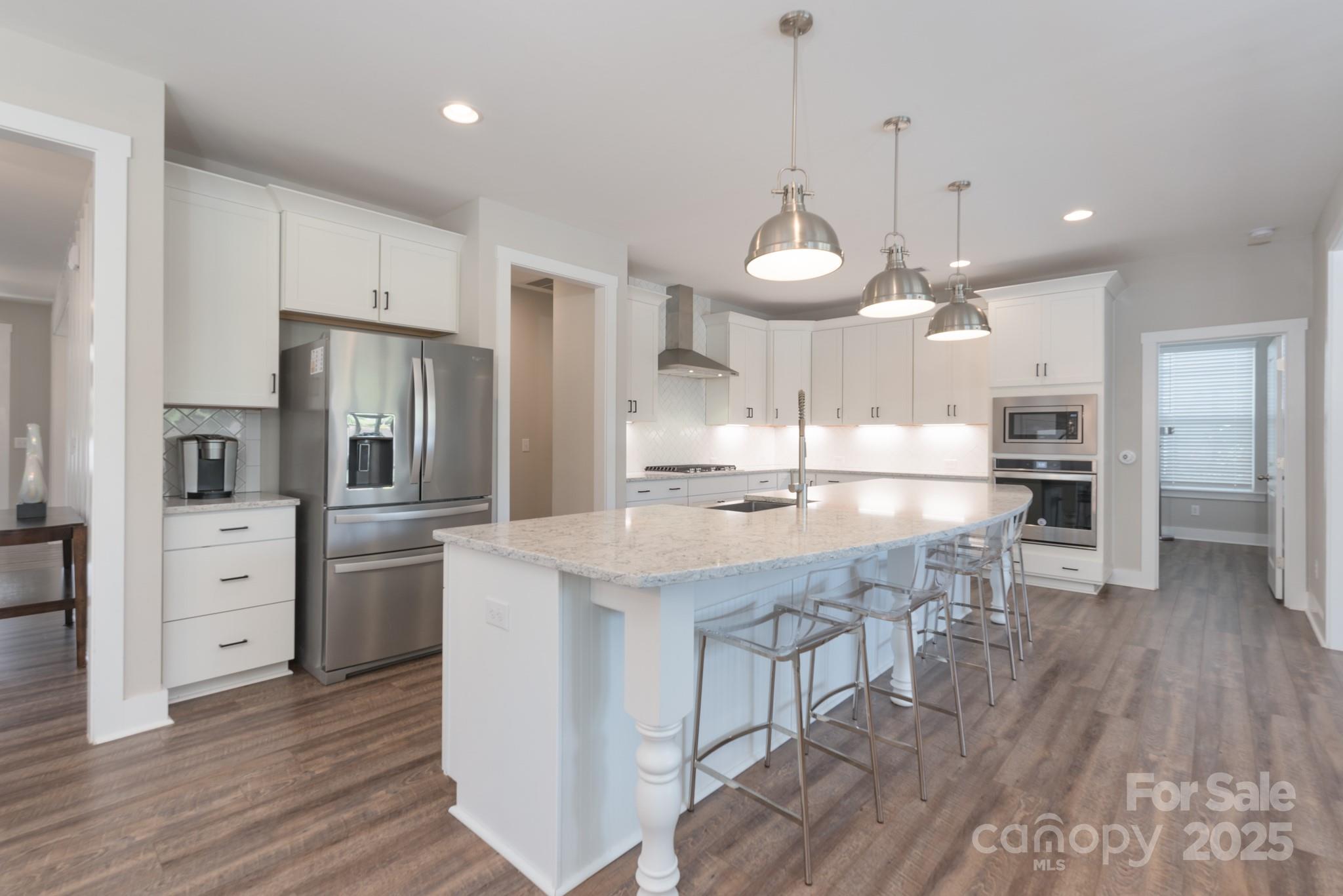 1180 Weir Court Fort Mill, SC 29708 - Photo 11 of 37 a kitchen with stainless steel appliances kitchen island granite countertop a refrigerator a stove and white cabinets with wooden floor
