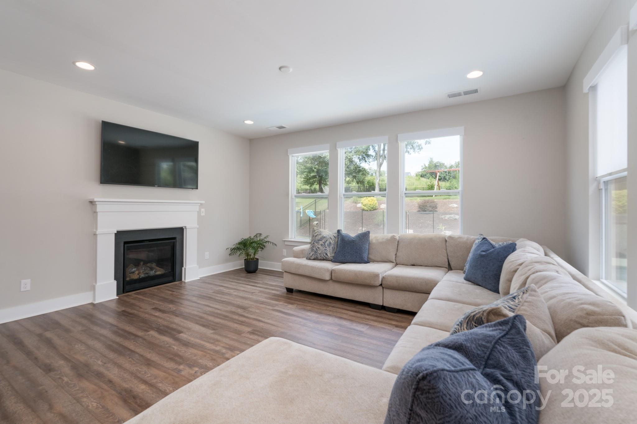 1180 Weir Court Fort Mill, SC 29708 - Photo 17 of 37 a living room with furniture a fireplace and a flat screen tv
