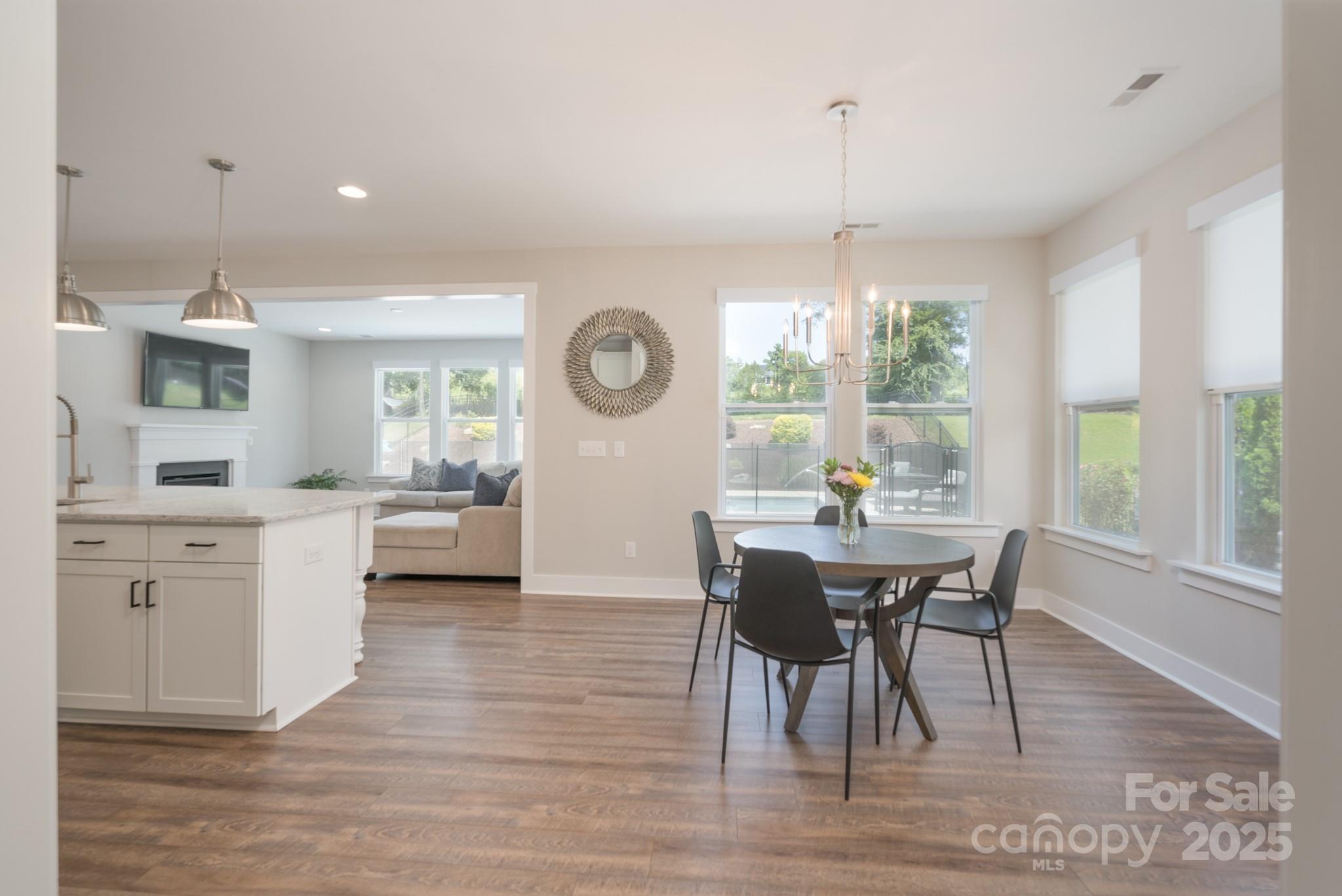 1180 Weir Court Fort Mill, SC 29708 - Photo 8 of 37 a dining room with wooden floor a chandelier a wooden table and chairs