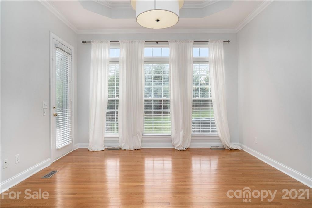 1416 Shade Tree Court Matthews, NC 28104 - Photo 12 of 22 an empty room with wooden floor and windows