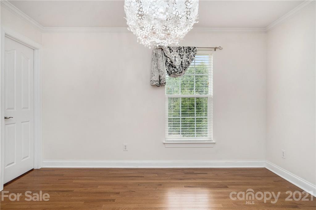 1416 Shade Tree Court Matthews, NC 28104 - Photo 15 of 22 a view of a livingroom with an empty space a window and wooden floor