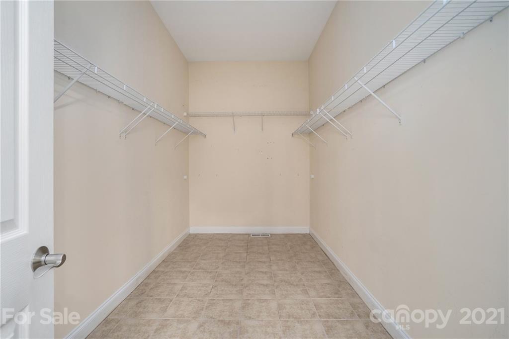 1416 Shade Tree Court Matthews, NC 28104 - Photo 21 of 22 a view of a room with shelf with racks on the wall